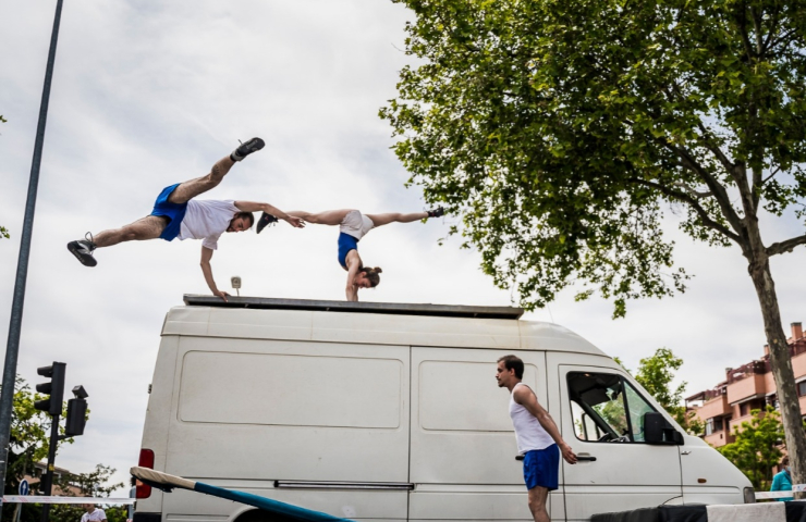 dos hombres haciendo acrobacias sobre una furgoneta