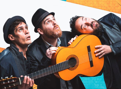 tres hombres con cara de sorpresa mirando hacia arriba con una guitarra